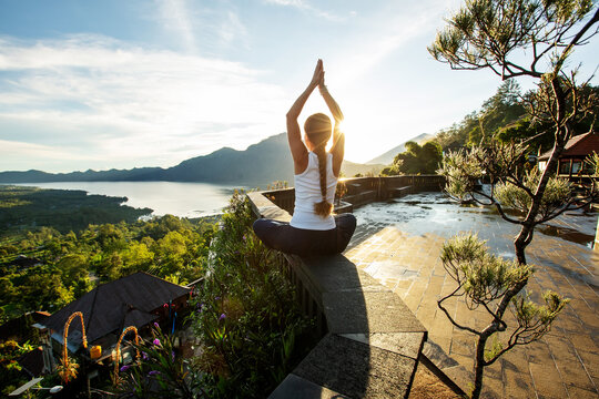 Woman doing yoga at dawn near a volcano on the island of Bali