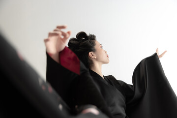 Portrait of young beautiful Japanese, woman in national attire kimono posing isolated over white...