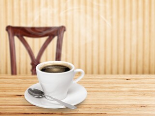 A white ceramic cup of hot black coffee on a wooden table, cafe concept.