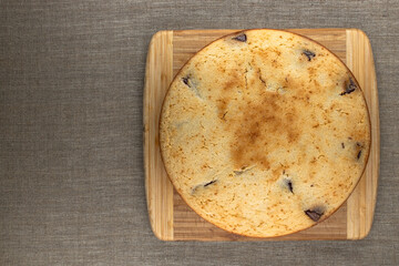 Freshly baked chocolate pie on wooden board on linen canvas
