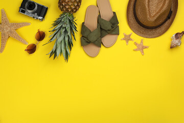 Flat lay composition with beach objects on yellow background, space for text