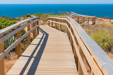 Fototapeta premium winding boardwalk at coastal landscape Lagos Portugal