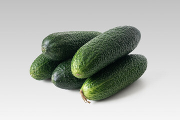 Ripe green cucumbers on a light background