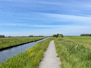 Fototapeta na wymiar Bicycle path next to a canal at the Weerribben-Wieden National Park