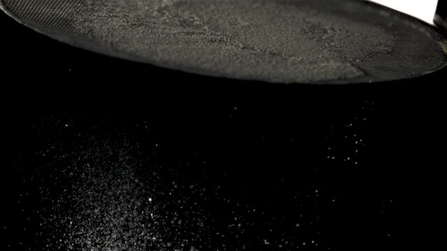 Super slow motion flour is sifted through a sieve to cook the pastry. Filmed on a high-speed camera at 1000 fps.On a black background. 