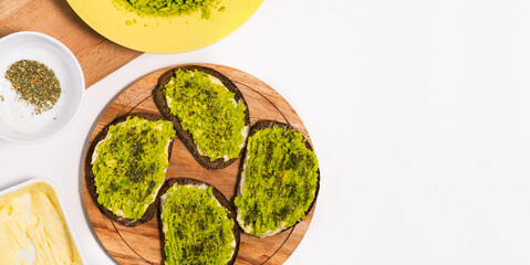 Top view of sandwiches with avocado and salad on a wooden surface. Healthy homemade creamy toast. Flat lay, copy space