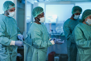 Fototapeta na wymiar Doctors preparing and getting dressed to work inside hospital during coronavirus outbreak - Health care medical worker