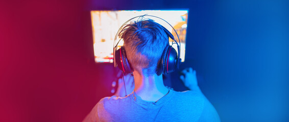 Professional gamer playing championship online games computer with headphones, banner background color red and blue