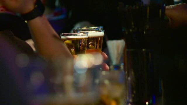 the bartender gives out glasses of beer to the bar customer