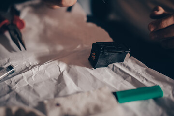 Male hands refill printer cartridge. The guy makes holes in the cartridge and pours ink through the...
