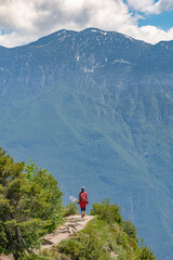Fototapeta premium nice and active senior woman riding her electric mountainbike on the famous Tremalzo downhill from Tremalzo Pass to Riva del Garda at Garda lake, Trentino, Izaly