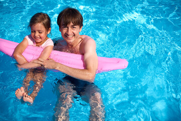 Dad and daughter are having fun in the pool. Family summer vacation in the pool. A happy family. Summer vacation
