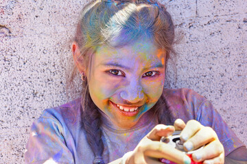 Closeup of a cute Spanish child looking at the camera with angelic eyes and paint over her face