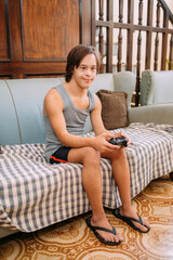 Young latin man with down syndrome playing video games at home.
