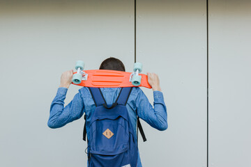 close up stylish man carrying the penny board in the summer city