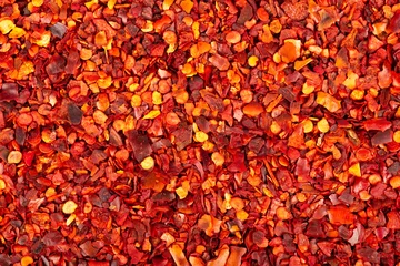 Keuken spatwand met foto Droge rode Spaanse pepervlokken met zadenachtergrond. Gehakte chili cayennepeper. Specerijen en kruiden. © vandycandy
