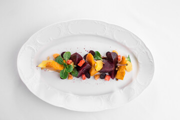 warm salad with baked pumpkin and beetroot on white plate isolated on white background