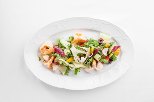 Shrimp salad with avocado and tomatoes on white plate isolated on white background