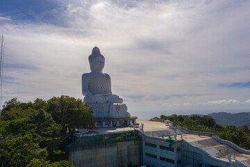 aerial photography Phuket big Buddha in sunny day.Phuket Big Buddha is one of the most important and revered landmarks on Phuket island..white cloud in blue sky, blue sea and mountain background © Narong Niemhom