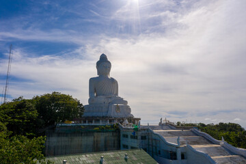 aerial photography Phuket big Buddha in sunny day.Phuket Big Buddha is one of the most important and revered landmarks on Phuket island..white cloud in blue sky, blue sea and mountain background © Narong Niemhom