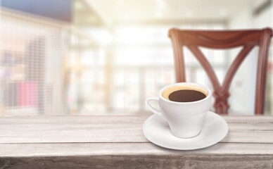 A white ceramic cup of hot black coffee on a wooden table, cafe concept.
