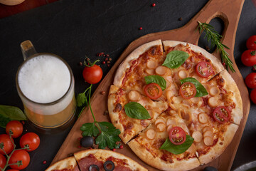 Family or friends having pizza party dinner. Flat-lay of people clinking glasses with drink over rustic dark stone table with various kinds of Italian pizza, top view. Fast food lunch, celebration