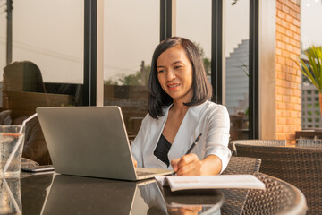 attractive  owner of big company,Portrait of business woman outdoor with coffee and laptop, smiling businesswoman using laptop computer and talking with cellphone, hand with pencil writing on notebook