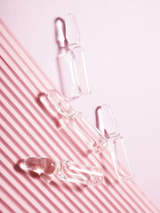 many medical ampoules on a pink background, vaccination and treatment
