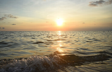 Orange sunset at sea, bright highlights on the waves