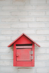 red vintage mail box hang on white brick wall