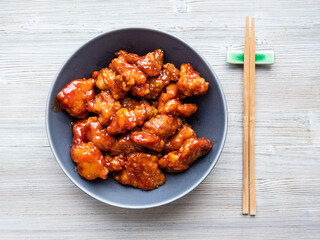 chinese cuisine - served sweet and sour pork (guo bao rou) in gray bowl on wooden table