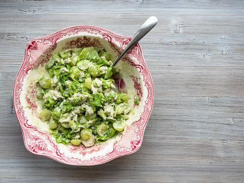 Top View Of Salad With Grapes, Tarragon And Chicken In Ornamental Bowl With Spoon On Gray Wooden Table