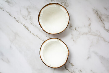 Obraz na płótnie Canvas Two halves of coconut on marble background. Top view