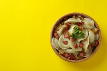 Concept of tasty food with vareniki or pierogi on yellow background
