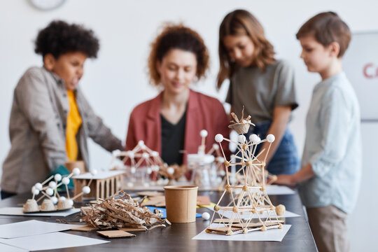 Female Teacher Helping Children Making Wooden Models During Art And Craft Class In School, Focus On Foreground, Copy Space