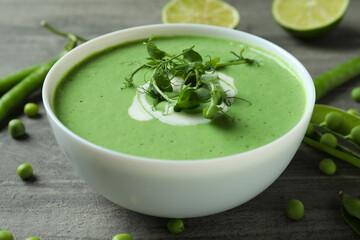 Concept of tasty eating with pea soup on gray textured table