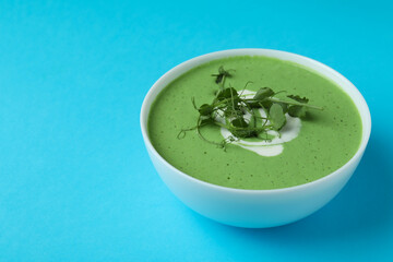 Bowl of pea soup on blue background