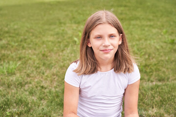 Little girl portrait. Outdoor green background. Looking. Teenager schoolgirl at park. Cute face. Children beauty. Female head. Charisma caucasian - obrazy, fototapety, plakaty