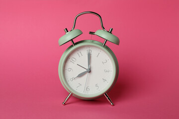 Stylish mint alarm clock on pink background