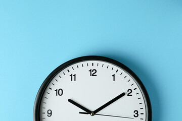 Standard black office clock on blue background