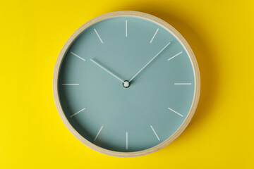 Standard wooden home clock on yellow background