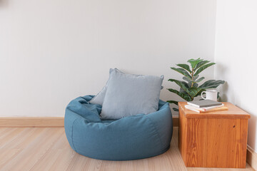 Blue bean bag in a clear living room with wooden floor and clear white wall.