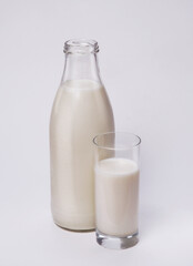 Bottle and glass of fresh milk on white background.