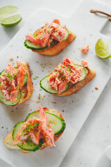 Toasts with smoked salmon and fresh cucumber served with lime shavings.