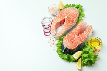 Fresh raw salmon and ingredients for cooking on white background