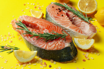 Fresh raw salmon and spices on yellow background