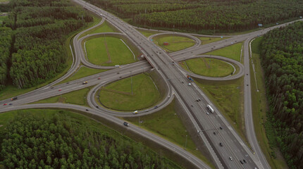 AERIAL. Traffic interchange. Top view of the road, city and forest. Summer video from the drone.