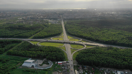 AERIAL. Traffic interchange. Top view of the road, city and forest. Summer video from the drone.
