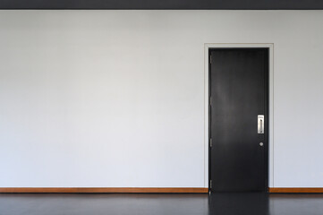 modern black Wooden door Closed Shut with metallic handle on white wall. Empty room interior. Free space for display or montage products.