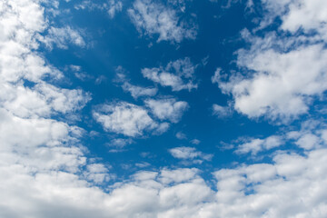 Naklejka na ściany i meble Blue sky with fluffy white clouds. Perfect natural sky background, wallpaper, greeting card